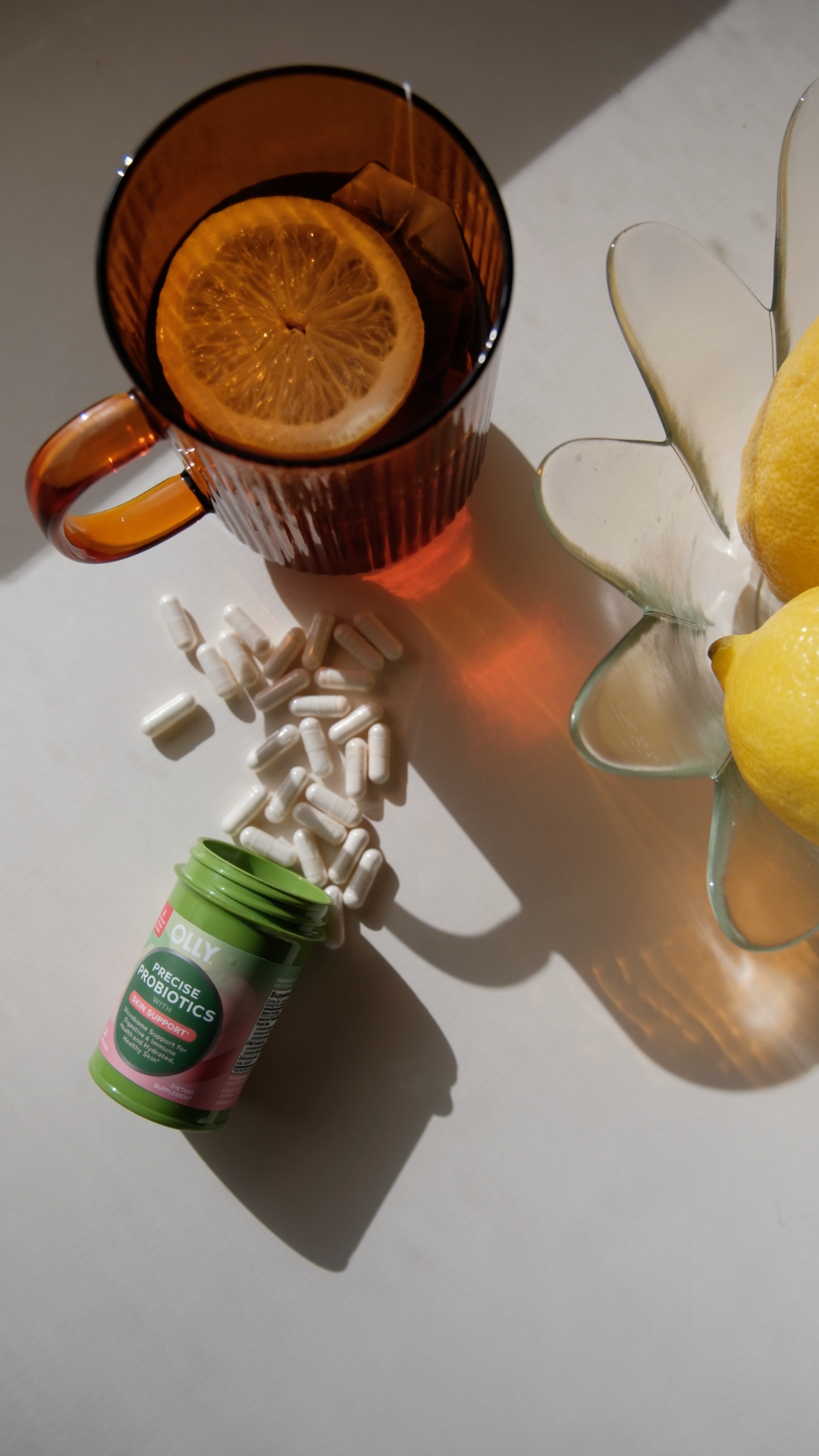 OLLY — Precise Probiotics capsules beside lemon drinks
