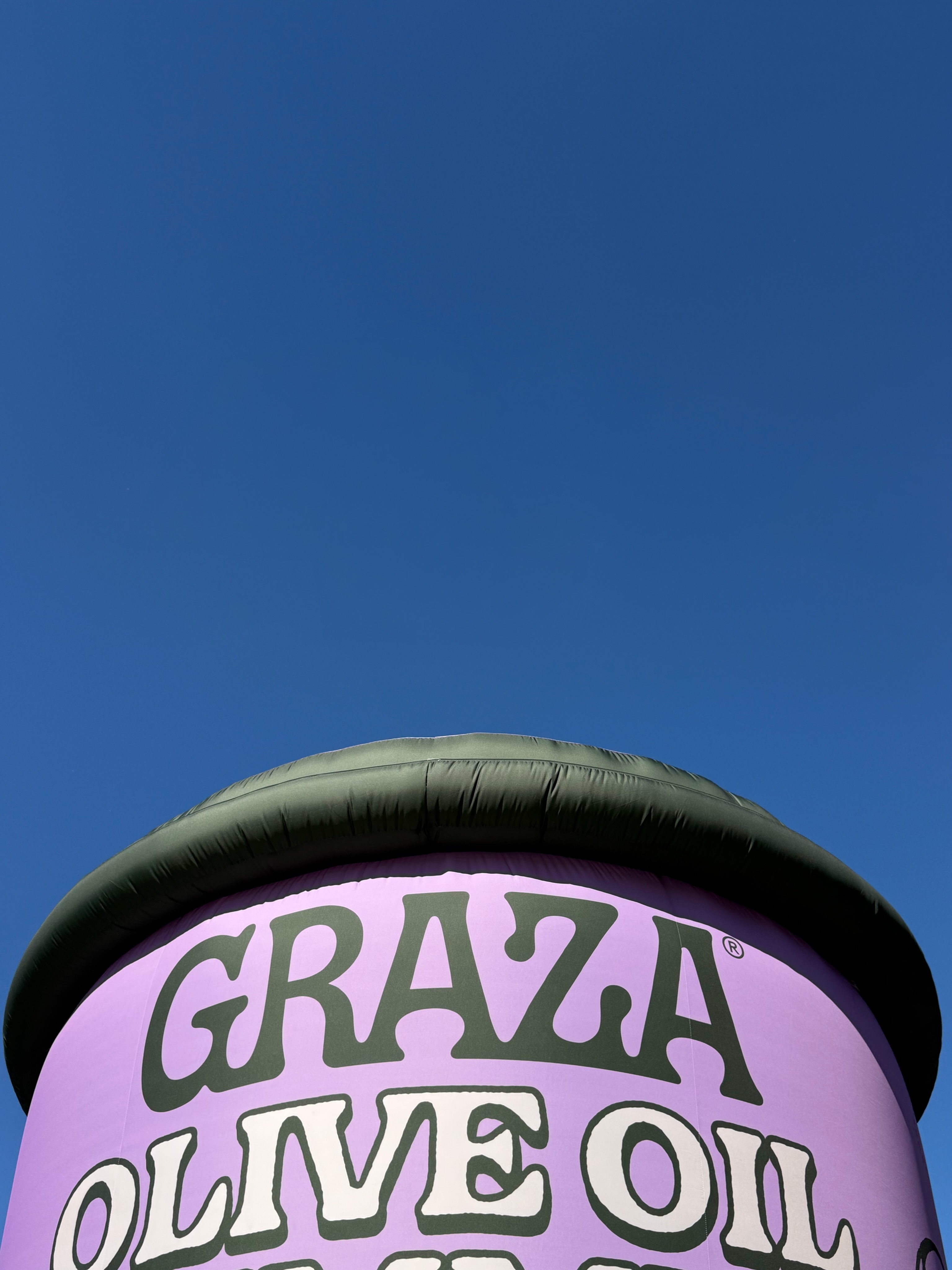 Graza — An oversized Graza hummus tub against a blue sky
