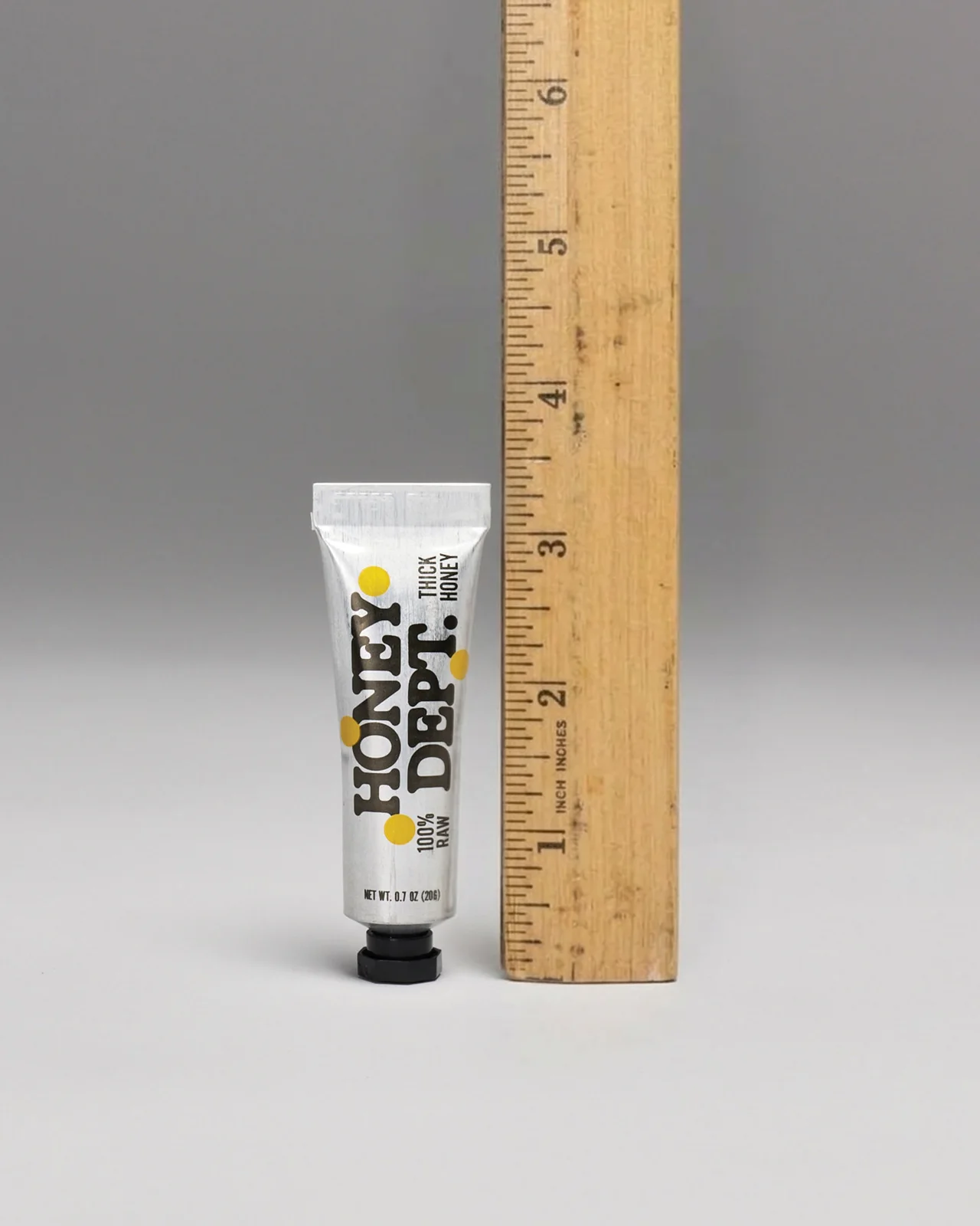 Honey Department — A pocket honey tube measured beside a wooden ruler