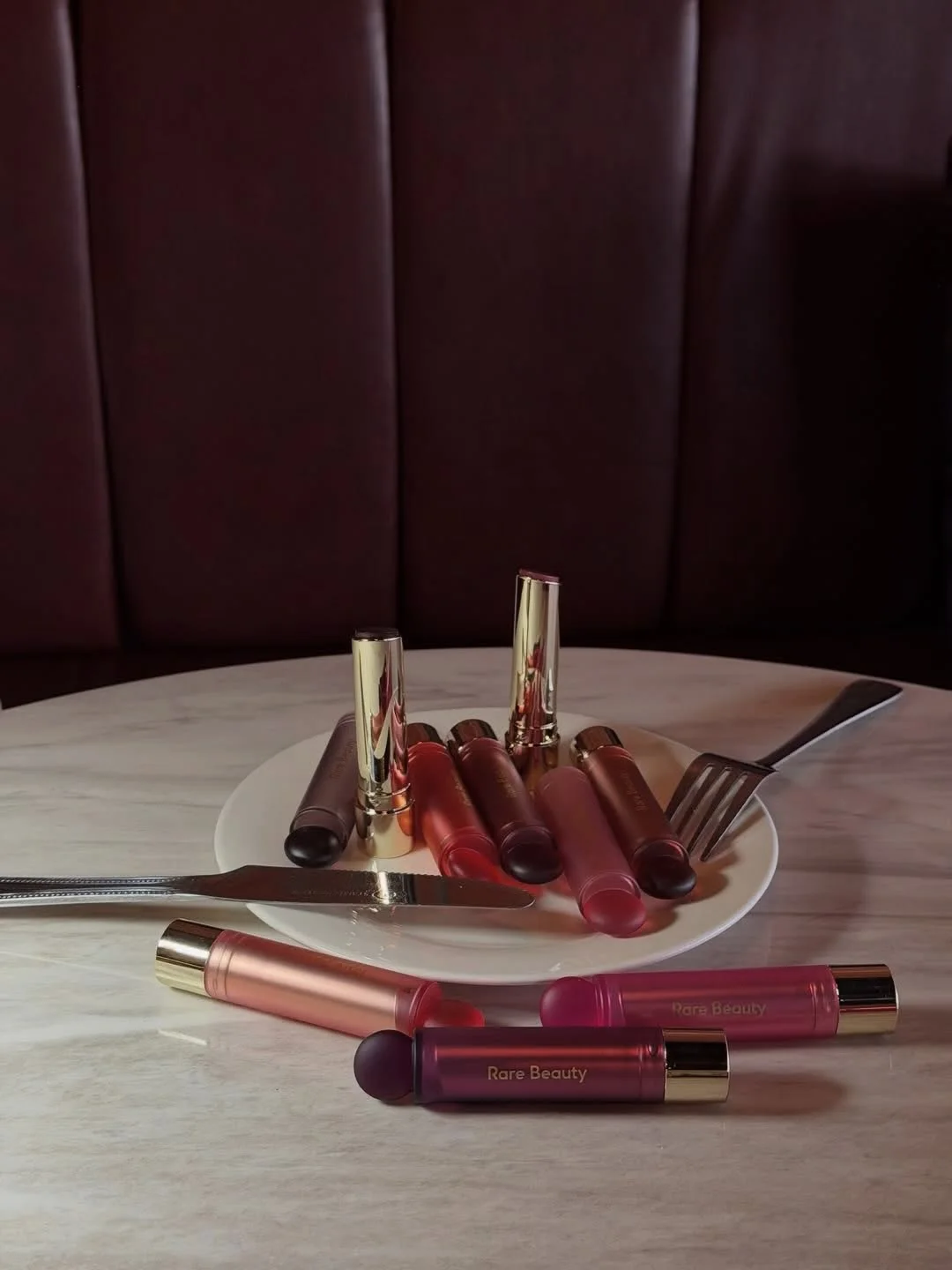 Rare Beauty — Soft Pinch Lip Oil Sticks served as a dinner-date still life