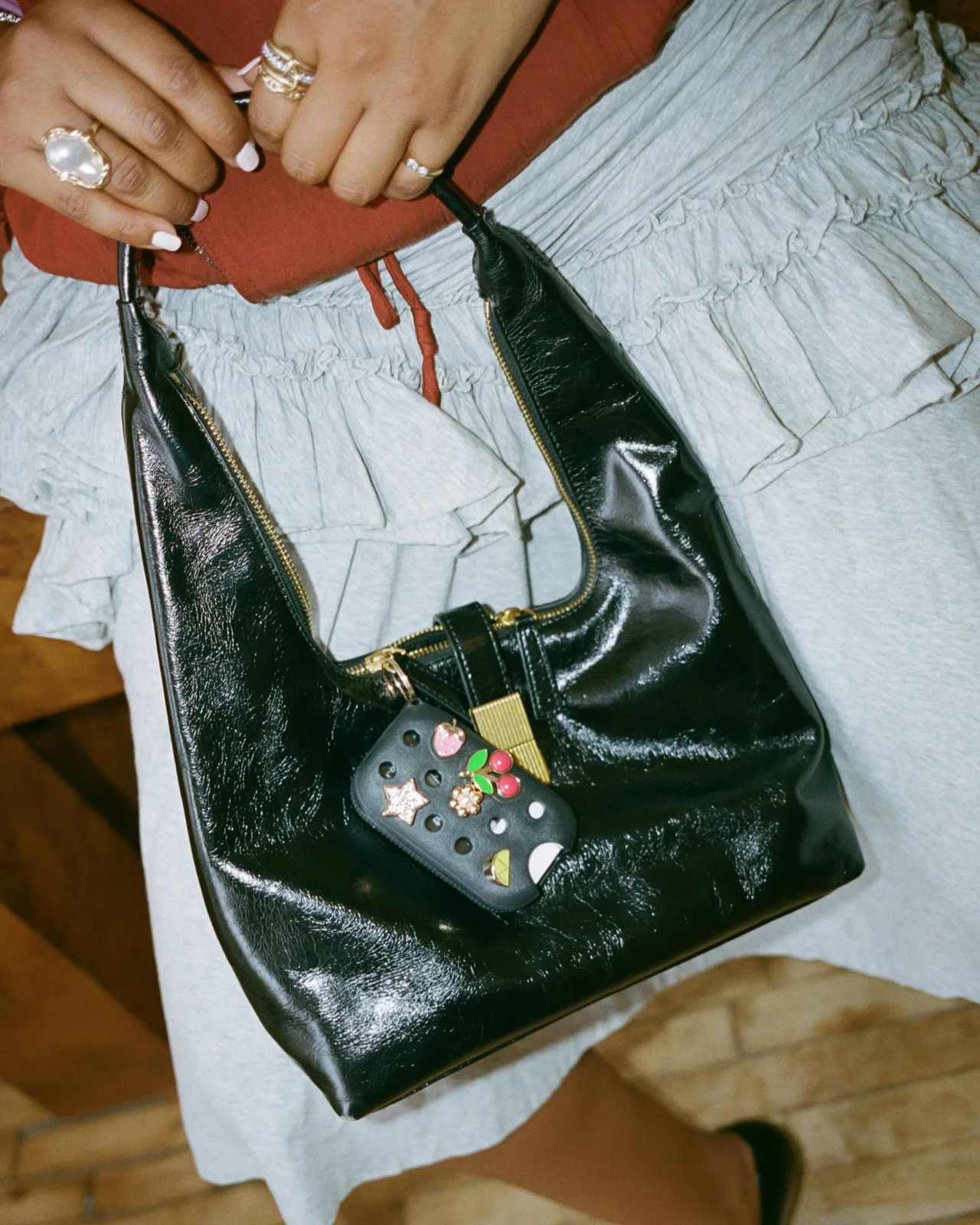 Touchland — A black Crocs x Touchland case styled on a handbag