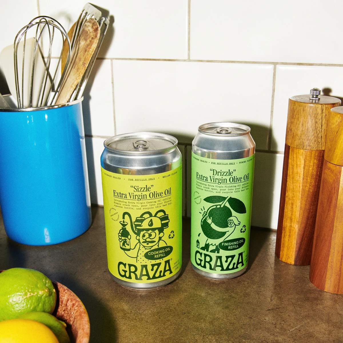 Graza Sizzle and Drizzle refill cans photographed on a kitchen counter