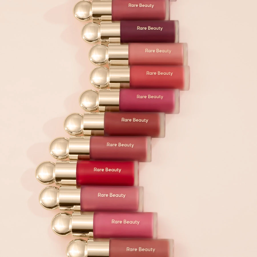 Rare Beauty Soft Pinch Liquid Blush bottles arranged diagonally, showing their rounded gold cap tops